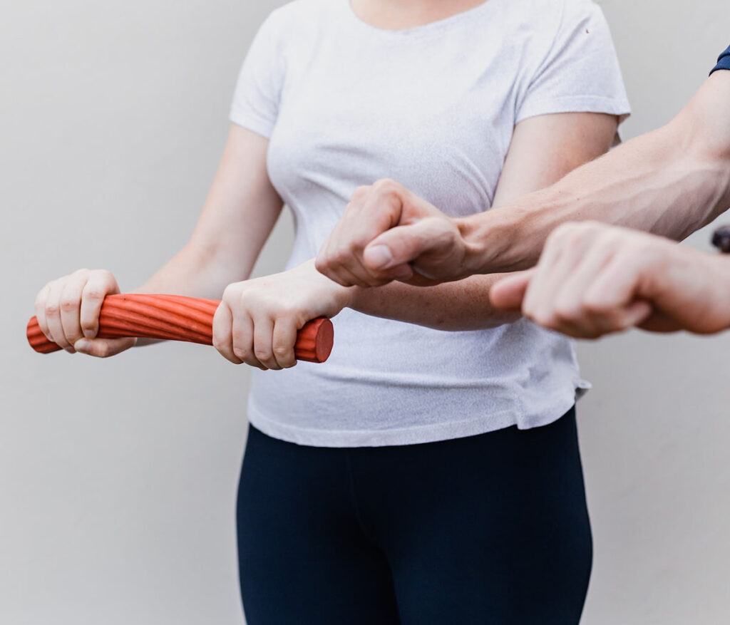 A person participating in physical therapy exercises to strengthen their wrist and upper extremities, with their Certified Hand Therapist in Scarborough, Maine.